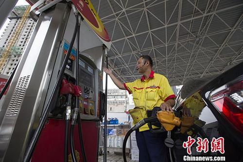 資料圖：一加油站工作人員給車輛加油。中新社記者張云攝